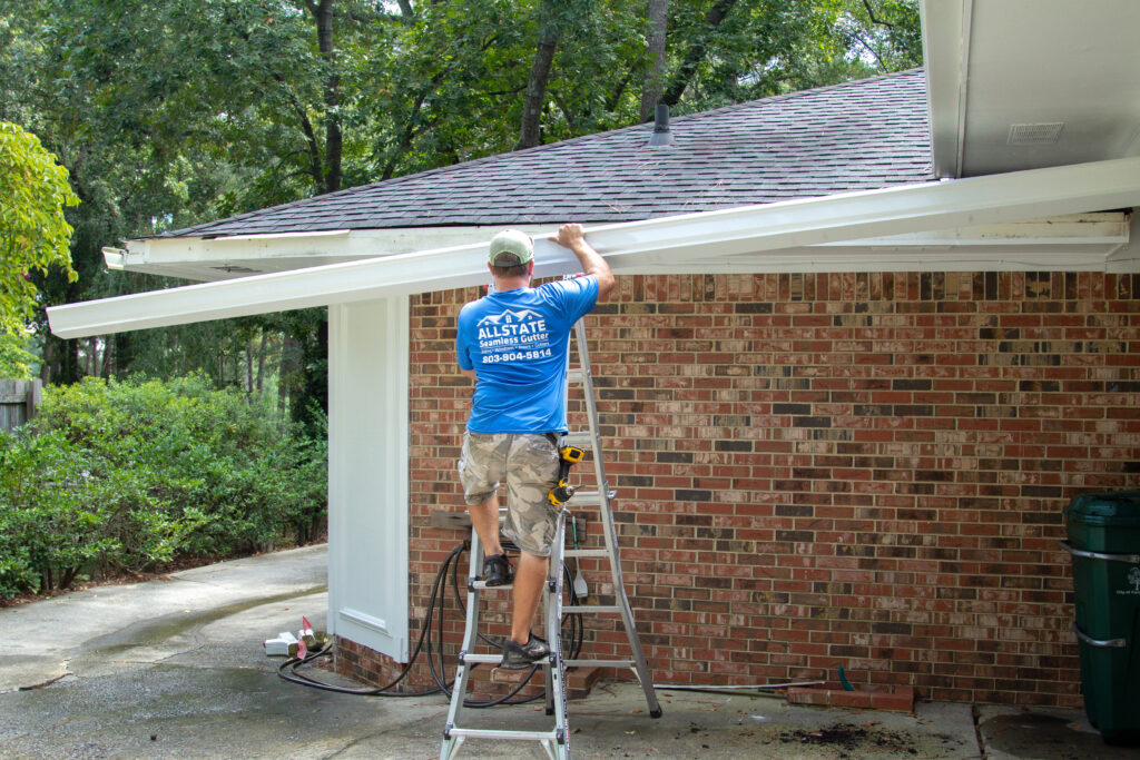 installing a new custom sized seamless aluminum gutter on house in Columbia SC by Columbia Gutter Pros